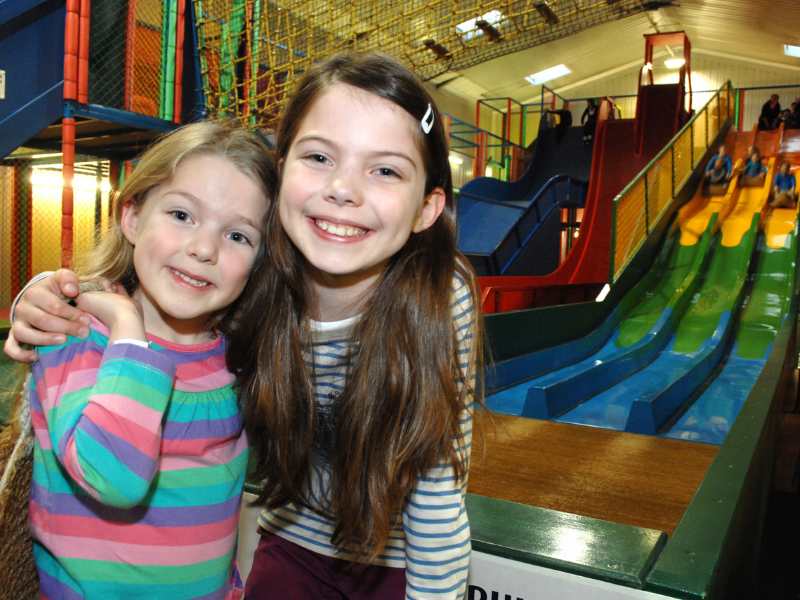 Young girls enjoying super slide mania soft play at halloween Spooktacular