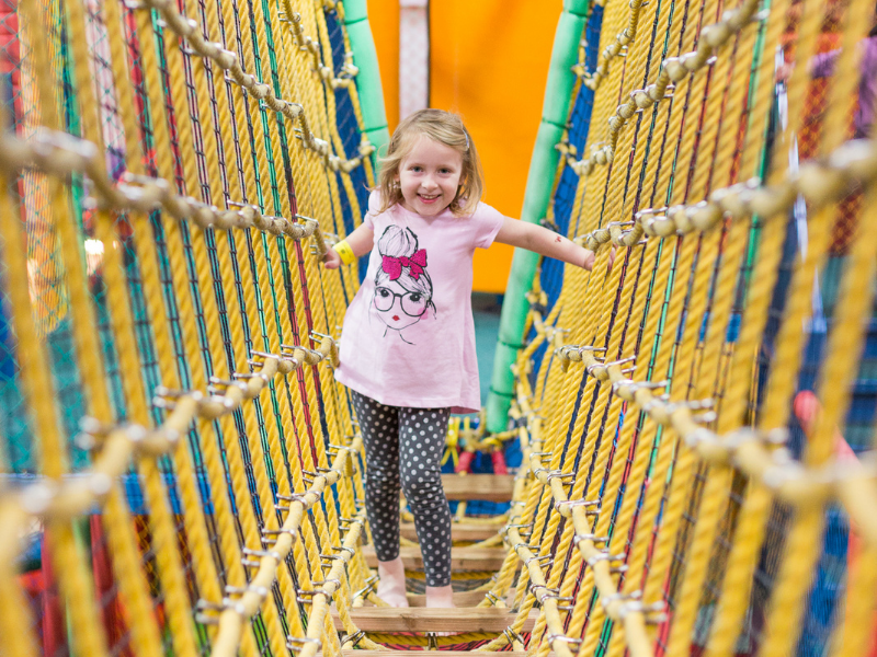 Girl climbing nets in soft play