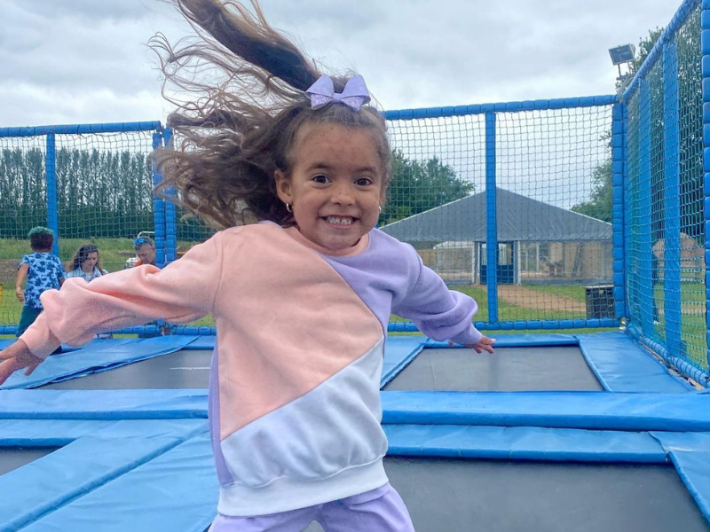 Child smiling, jumping on Hatton adventure world trampoline beds at halloween
