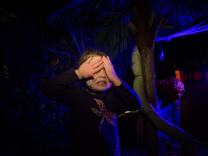 Young girl covering her eyes from a spooky family freindly halloween uv trail
